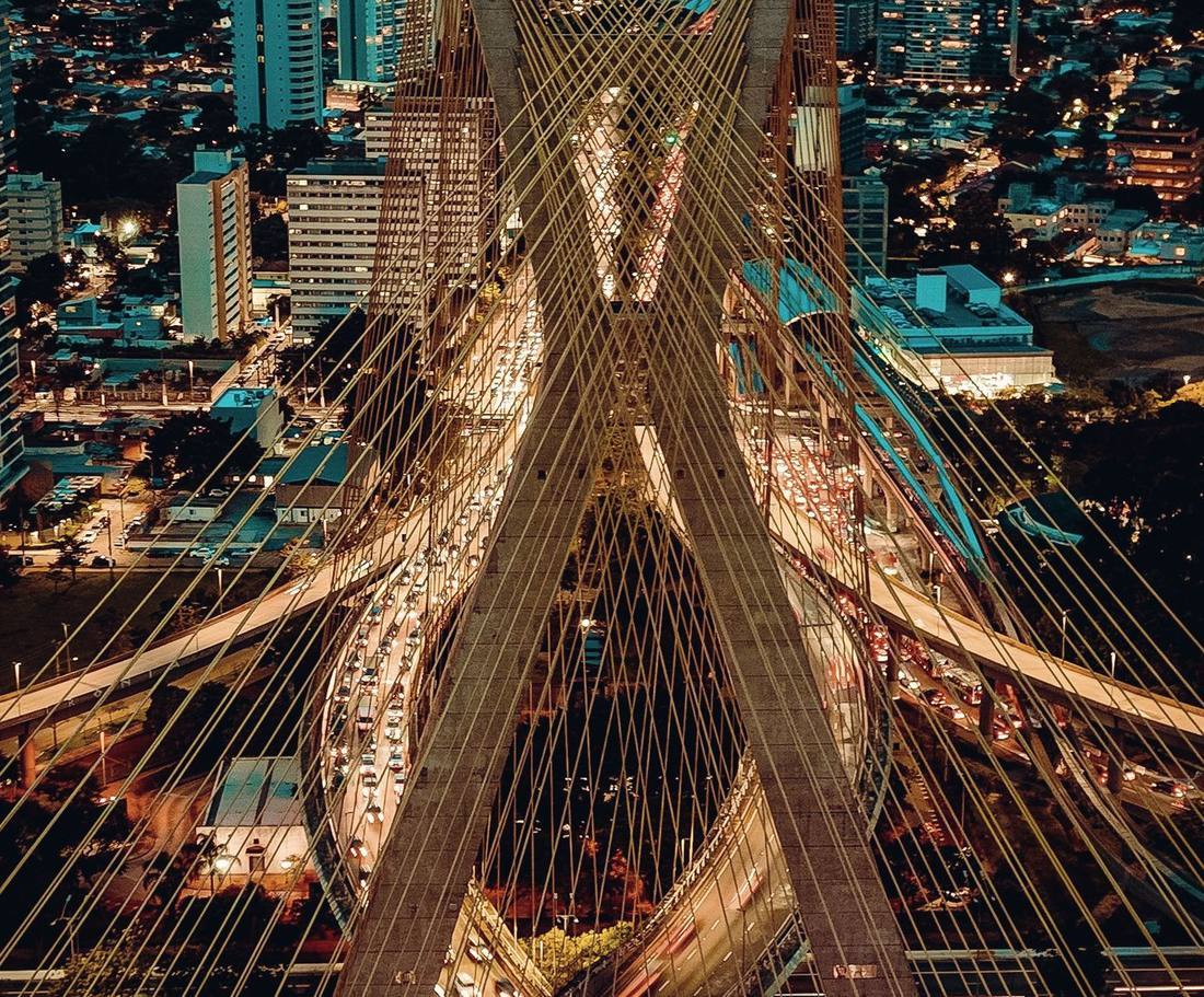 Cable-stayed bridge and converging roads lit at night