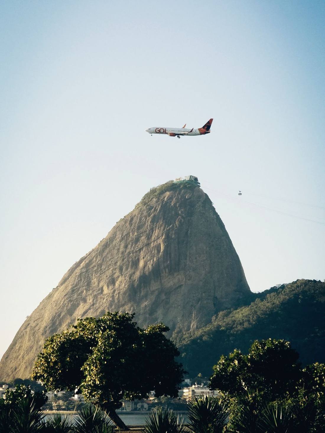 An aircraft on approach past a coastal mountain